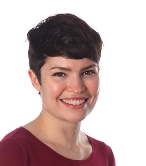 Photo of Jennifer Oliver smiling to camera, sitting in front of a white background. 